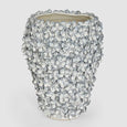 tall blue and white stoneware vase with hand-applied floral texture detail on a grey background