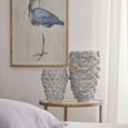 blue and white floral vase styled on bedside table with coastal artwork and decor