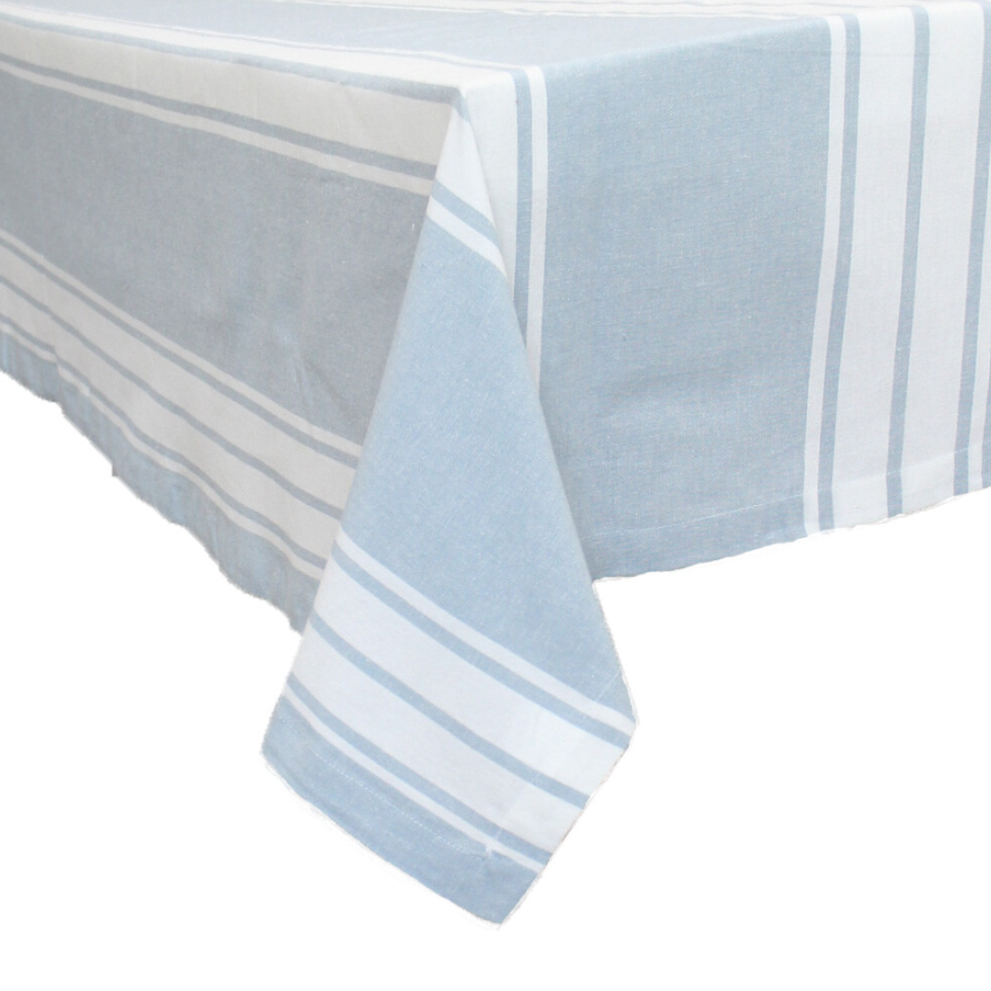 Blue Bay Stripe Chambray cotton tablecloth in soft blue and white coastal stripes draped over a dining table.