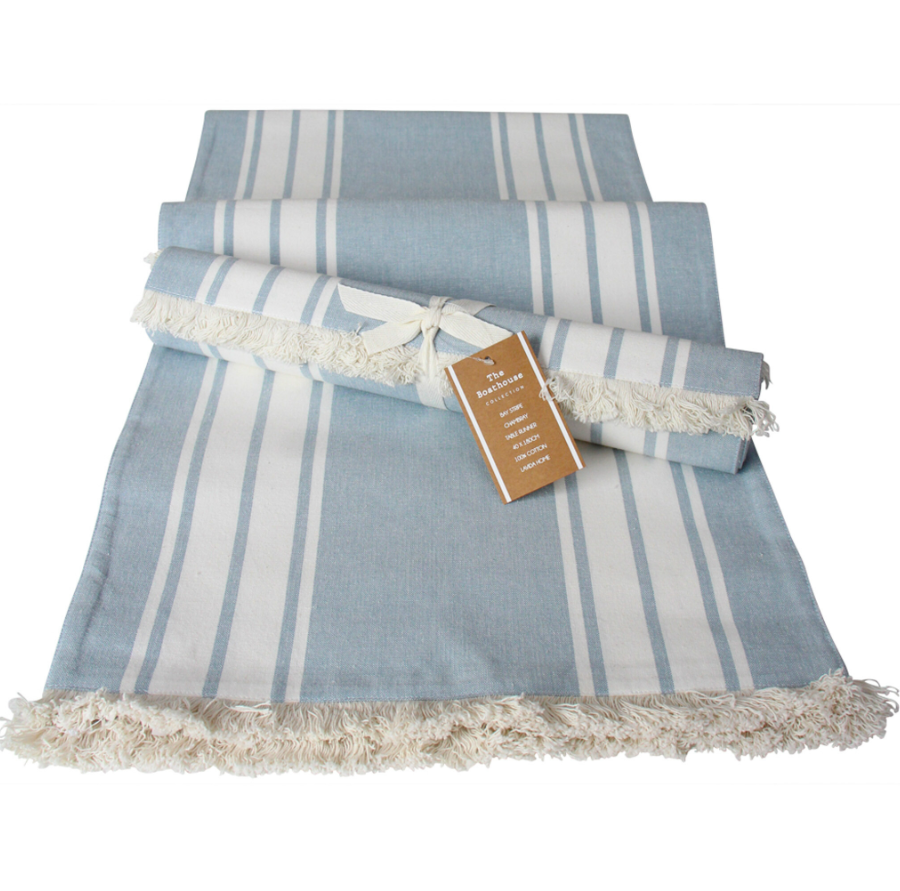 Blue chambray striped cotton table runner with frayed edges laid flat
