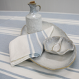 Blue Bay Stripe Chambray tablecloth styled with coordinating striped napkin and neutral ceramic tableware.