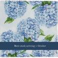 blue hydrangea floral paper napkin design close-up in soft coastal tones with a more stock arriving october banner in blue at the bottom