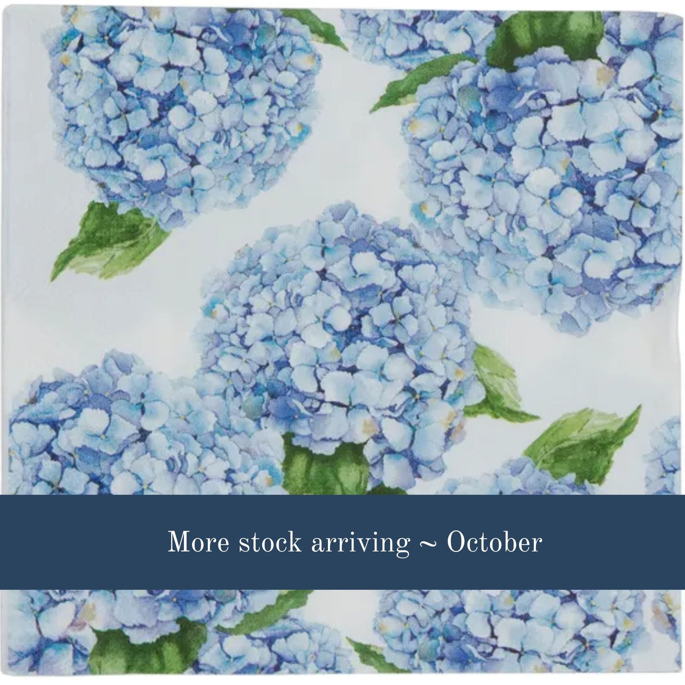 blue hydrangea floral paper napkin design close-up in soft coastal tones with a more stock arriving october banner in blue at the bottom