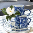 Blue and white ceramic jug styled on a tray with decorative bird and magnolia stem