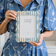 Bluebell Stripe Floral 5x7 photo frame held in a coastal-inspired setting with white hydrangeas and blue and white décor, showcasing its delicate floral detailing and scalloped design.