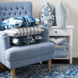 Bayside Slate Blue Button Tufted Armchair styled with blue and white cushions, rug and white Hamptons furniture.