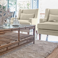 Pair of Bondi Hamptons Armchairs in natural upholstery styled in a relaxed coastal living room with rattan coffee table.