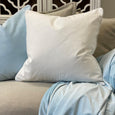 Bondi Ivory Cushion 60cm styled on a neutral sofa with soft blue and natural cushions in a Hamptons interior