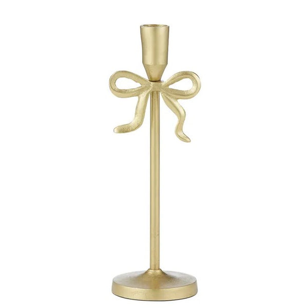 Gold metal candle holder with decorative bow detail and slender base, styled for elegant coastal home décor