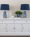 boxwood greenery styled in blue and white vase on hamptons sideboard