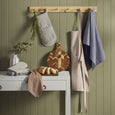navy and white stripe tea towel hanging in kitchen with apron and utensils styled