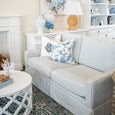 Camden Marine Stripe 2.5 Seat Skirted Sofa styled in a bright Hamptons living room with blue floral cushions, white furniture and coastal décor.