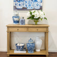 Blue and white motif canister styled on a timber console table with hydrangeas, ginger jars and Hamptons-inspired artwork.