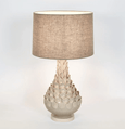 Elegant ceramic table lamp with linen shade creating warm ambient lighting in a living room
