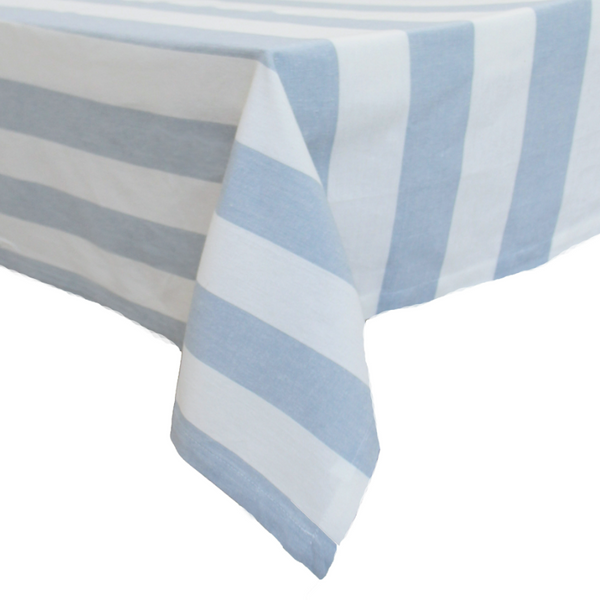 Chambray Stripe Blue Bold Stripe stonewashed cotton tablecloth featuring bold blue and white stripes draped over a dining table.