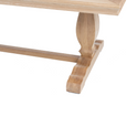 Close-up of sculpted pedestal leg and stepped trestle foot on the Charlotte Natural Oak dining table.