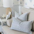 Layered blue cushions on a neutral sofa featuring cadet pattern and stripe designs