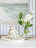 White ceramic plate styled with decorative vase and greenery on console