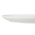 Side view of white ceramic plate showing textured braided rim detail