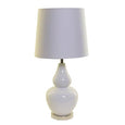 Classic coastal ceramic table lamp with metal base and white linen shade styled in a Hamptons interior
