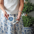 Coastal Coasters Set of 4 in blue and white with scallop shell and nautilus designs in a relaxed Hamptons setting.