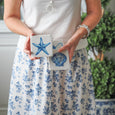 Blue and white Coastal Coasters Set of 4 featuring starfish and scallop shell designs styled in a relaxed Hamptons setting.