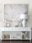 Coastal console table styled with wooden coin and key boxes, lamps and decorative accessories