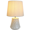 Coastal-inspired ceramic bedside lamp with textured seashell-style base and neutral fabric shade
