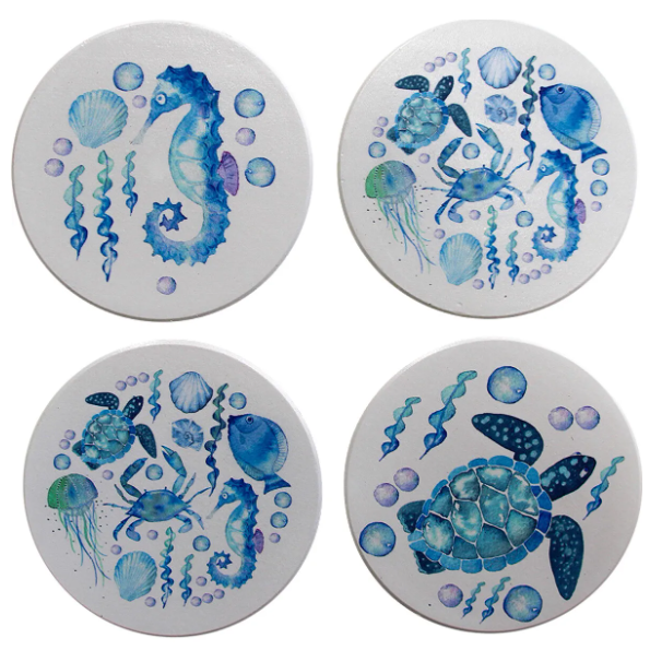 Set of four coastal ceramic coasters featuring watercolour illustrations of a seahorse, sea turtle, fish, shells and marine life in calming shades of blue.