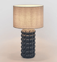 Blue ceramic table lamp with soft linen shade creating warm ambient lighting
