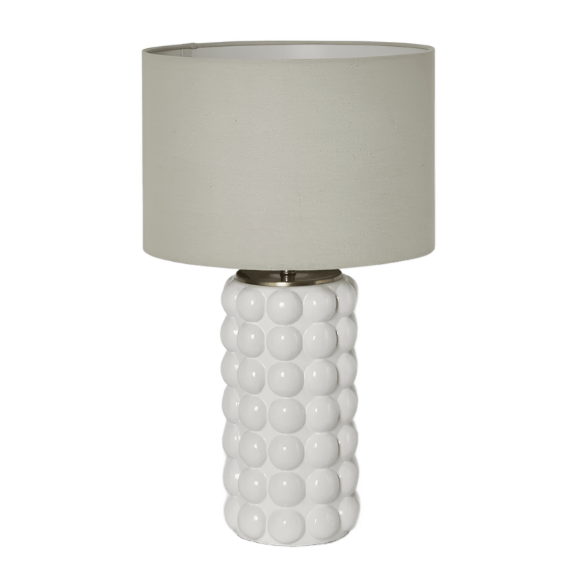 Condetti white ceramic table lamp with raised spherical detailing and natural linen shade on a side table