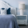 White bubble ceramic table lamp on blue bedside table in coastal bedroom.