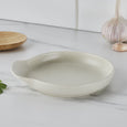 Cream speckled stoneware spoon rest styled on a marble kitchen benchtop beside garlic and wooden utensils