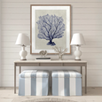 Designer Boys Coral SPLENDOUR Indigo X artwork styled above a console with white lamps and blue striped stools in a Hamptons coastal interior.