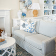Diamond Monogram White Cushion Cover styled on a blue striped Hamptons sofa with blue floral cushions in a classic coastal living room.