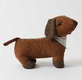 Brown corduroy dog-shaped door stop with herringbone paws and ears, featuring a grey scarf and weighted design for holding doors open. Side view.