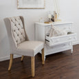 Eastport buttoned linen chair styled as an occasional chair beside a white chest of drawers