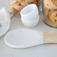 Eliot marble spoon rest styled on a kitchen bench beside pasta jars and marble bowls.