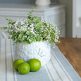 Eliza Ceramic Pot styled with green eucalypt and white faux flowers on a blue striped table runner