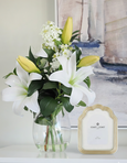 Ella Resin Frame Gold 5x7 with sculpted wavy-edge design and gold detailing, styled on a console beside a glass vase of white lilies in a Hamptons-style interior