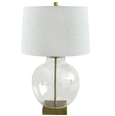 Ellyn Glass and Brass Table Lamp featuring a round clear glass base, brass-finished hardware and white linen shade.