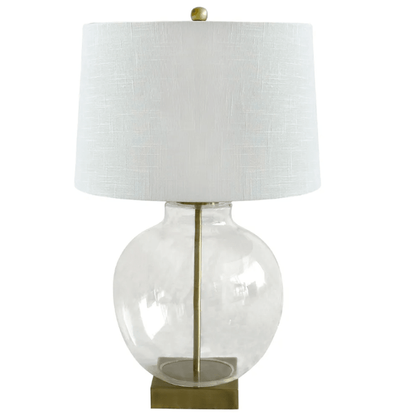 Ellyn Glass and Brass Table Lamp featuring a round clear glass base, brass-finished hardware and white linen shade.