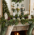 Empere nutcracker trio styled on Christmas mantel with greenery and stockings