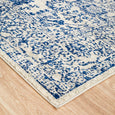 Corner detail of Eve Blue Rug showing distressed floral pattern and soft low-pile texture
