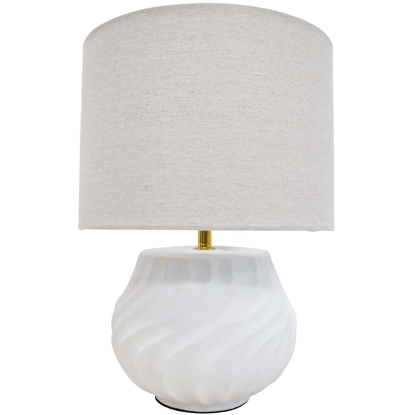 Flynn white ceramic table lamp with linen shade styled on a bedside table in a coastal Hamptons bedroom