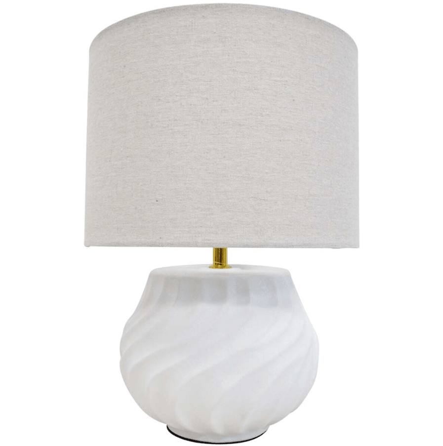 Flynn white ceramic table lamp with linen shade styled on a bedside table in a coastal Hamptons bedroom
