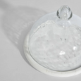 Close-up of glass dome and marble base with natural veining