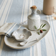 French Stoneware Oil & Vinegar Bottle styled with blue and white striped table linen and rustic stoneware serving pieces.