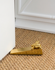 Gold bee door wedge doorstop on natural jute rug, decorative brass door stop for Hamptons style coastal home decor