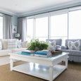 Close-up styling of Hampton Square Coffee Table with blue and white ceramics, books, and fresh greenery